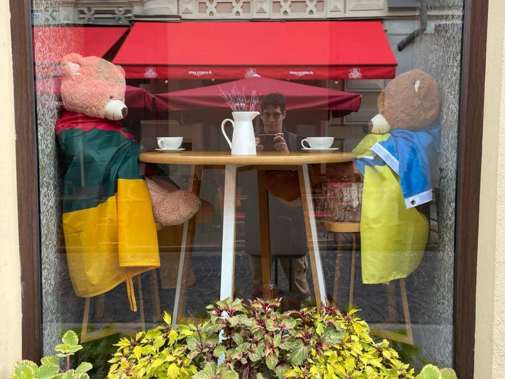 Qurio co-founder Spyros Tzortzis taking picture of two teddy bears wearing the Lithuanian and Urkanian flags